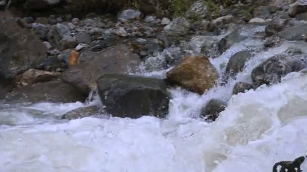 Närbild stenar och spray av en stormig berg flod i slow motion med spårning ledningar. Begreppet global uppvärmning och problemet med mängden färskt vatten på planeten — Stockvideo