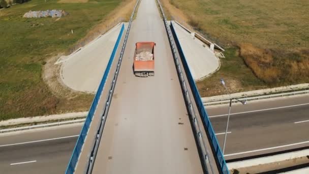 Aerial view of a truck. A dump truck transporting construction debris stones and sand in a truck rides along a country road. Trucking logistics cargo delivery — Stock Video