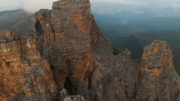 Вид з повітря на безпілотник, що летить над гострими скелястими виходами на заході сонця. Гострі круті гірські породи для екстремального альпінізму. Політ над мандрівним відео — стокове відео