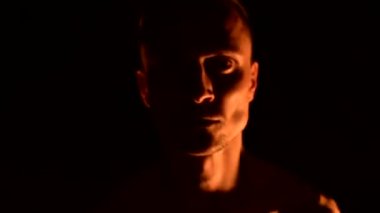 Siyah pantolonlu genç bir adamın karanlığa yakın yavaş hareketi, dönen yanan bir meşalenin temsilini gösterir. Meditasyon hareket halinde. Sakin ve sarsılmaz. Ateşle çalış. Düşük anahtar