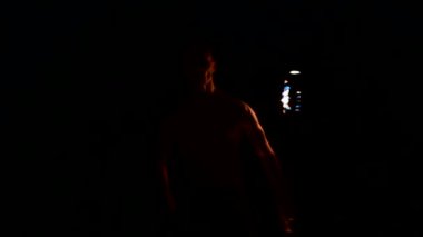 Siyah pantolonlu genç bir adamın karanlığa yakın yavaş hareketi, dönen yanan bir meşalenin temsilini gösterir. Meditasyon hareket halinde. Sakin ve sarsılmaz. Ateşle çalış. Düşük anahtar