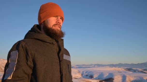 Um homem está ao pôr-do-sol acima das nuvens e contempla o pôr-do-sol. O conceito de tranquilidade e prazer em viajar — Vídeo de Stock