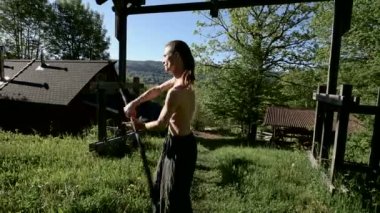 Orta Uzun atış Sabah eğitim bir yangın gösterisi için uzun saçlı bir adam. Meşaleler ve zincirler ile ateş olmadan bir performans için hazırlık