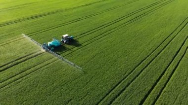 Krasnodar, Rusya - 24 Mayıs 2019: Havadan Görünümü Tarım makineleri Belarus traktörü ile bir sulama römorkberthoud tarım ürünlerinin yeşil alan üzerinden sürmek ve sulama yürütmektedir.