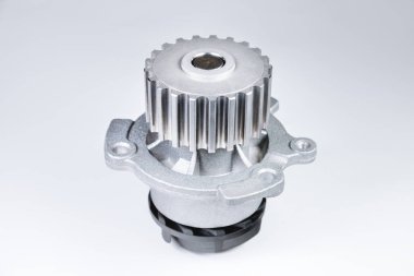 Bir degrade ile gri bir arka plan üzerinde bir motor su pompası soğutma için yeni metal otomobil pompası. Otomobil motoru için yeni yedek parça konsepti