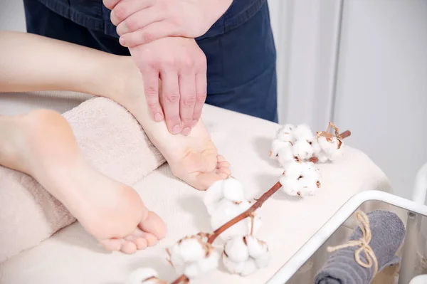 Close-up Massagem relaxante nos pés no spa. Mãos masculinas amassam o pé feminino. Conceito de cuidado corporal — Fotografia de Stock