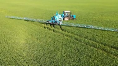 Krasnodar, Rusya - 24 Mayıs 2019: Havadan Görünümü Tarım makineleri Belarus traktörü ile bir sulama römorkberthoud tarım ürünlerinin yeşil alan üzerinden sürmek ve sulama yürütmektedir.
