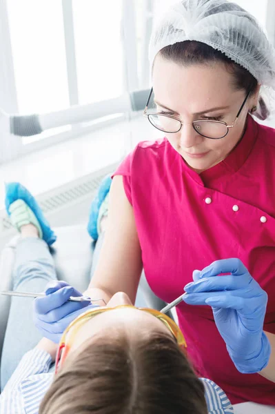 In der Zahnarztpraxis. Eine Zahnärztin mit Brille bereitet sich darauf vor, den Kiefer einer jungen Patientin abzuformen. Pflege sauberer Mund — Stockfoto