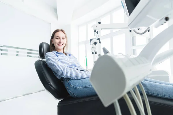 Portré vonzó mosolygós lány szőke egy fogászati szék. Boldog ügyfél fogászati kabinet — Stock Fotó
