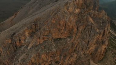 Gün batımında keskin kayalık çıkıntılar üzerinde uçan bir drone havadan görünümü. Aşırı dağcılık için kaya oluşumları Keskin dik dağ. Seyahat video üzerinde Uçuş