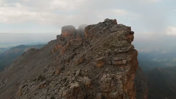 Veduta aerea di un drone che sorvola acuti affioramenti rocciosi al tramonto. Montagna scoscesa e ripida di formazioni rocciose per l'alpinismo estremo. Volo sopra il video di viaggio — Video Stock