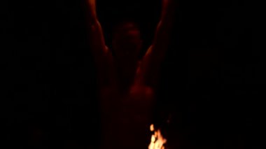 Siyah pantolonlu genç bir adamın karanlığa yakın yavaş hareketi, dönen yanan bir meşalenin temsilini gösterir. Meditasyon hareket halinde. Sakin ve sarsılmaz. Ateşle çalış. Düşük anahtar