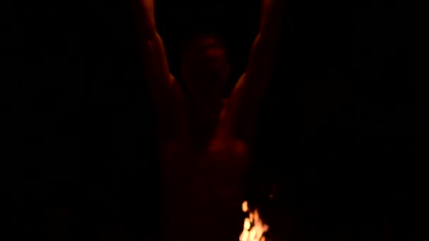 Mișcarea lentă a unui tânăr în pantaloni negri în întuneric total arată o reprezentare a unei torțe rotative în flăcări. Meditație în mișcare. Calmă şi neclintită. Lucrează cu focul. Cheie scăzută — Videoclip de stoc