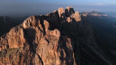 Gün batımında keskin kayalık çıkıntılar üzerinde uçan bir drone havadan görünümü. Aşırı dağcılık için kaya oluşumları Keskin dik dağ. Seyahat video üzerinde Uçuş