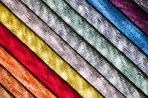 Colorful and bright fabric samples of furniture and clothing upholstery. Close-up of a palette of textile abstract diagonal stripes of different colors