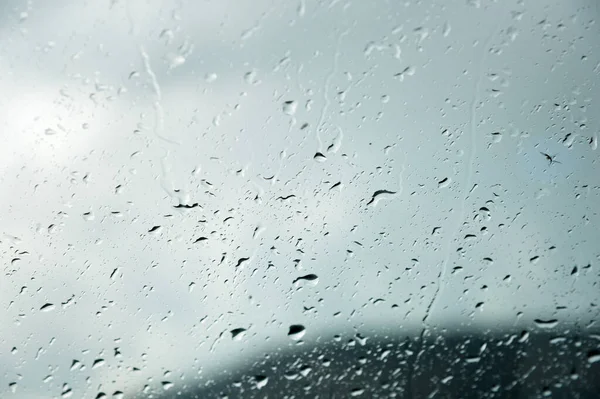 Естественный фон Капли по обе стороны стекла от дождя и от тумана абстрактный вид, капли дождя против синего стекла и размытый ландшафт градиента синего и зеленого — стоковое фото