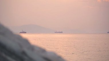 Günbatımında yelken açan birkaç konteyner gemisinin profesyonel görüntüsü