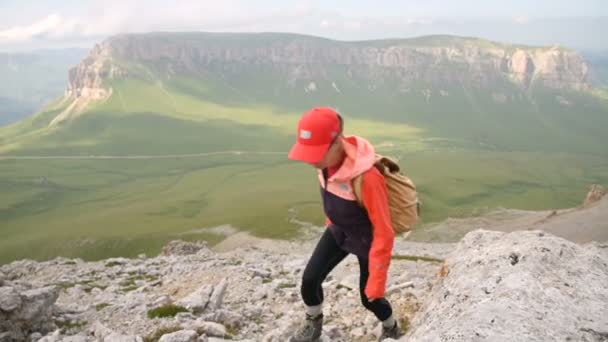 Punto de vista de escaladores felices que llegan a la cima de la montaña con vistas increíbles contra el telón de fondo de una meseta rocosa y el horizonte. El concepto de equipo de asistencia mutua. Cámara en vivo — Vídeos de Stock