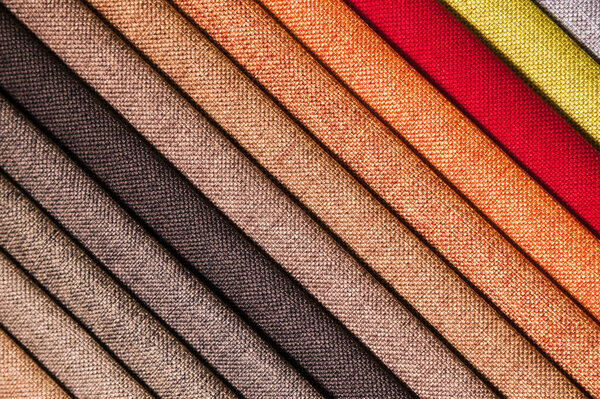 Colorful and bright fabric samples of furniture and clothing upholstery. Close-up of a palette of textile abstract diagonal stripes of different colors