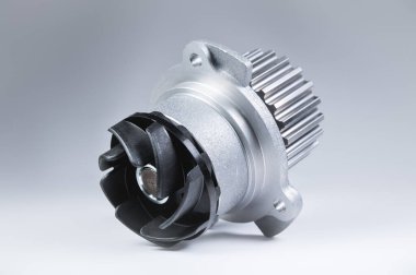 Bir degrade ile gri bir arka plan üzerinde bir motor su pompası soğutma için yeni metal otomobil pompası. Otomobil motoru için yeni yedek parça konsepti