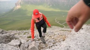 Bir grup mutlu dağcı dağın zirvesine ulaşırken kayalık bir plato ve ufukta inanılmaz manzaralar görüyorlar. Karşılıklı yardım ekibi kavramı. Canlı kamera