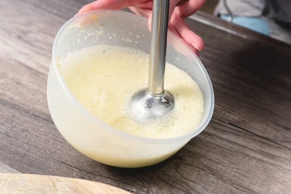Close-up whipping the mixture of homemade mayonnaise with a blender in a plastic bowl — Stock Photo, Image