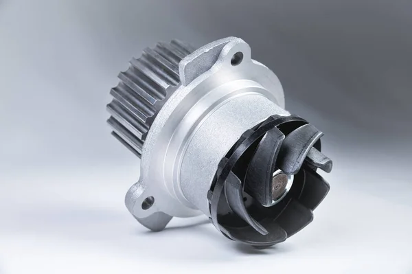 New metal automobile pump for cooling an engine water pump on a gray background with a gradient. The concept of new spare parts for the car engine — Stock Photo, Image