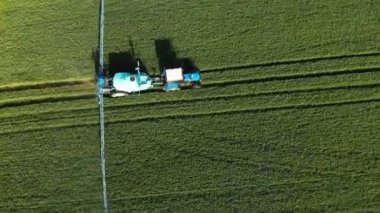 Krasnodar, Rusya - 24 Mayıs 2019: Havadan Görünümü Tarım makineleri Belarus traktörü ile bir sulama römorkberthoud tarım ürünlerinin yeşil alan üzerinden sürmek ve sulama yürütmektedir.