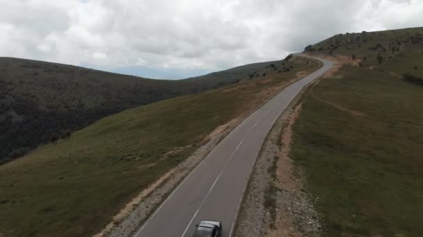 ПЯТИГОРСК, РОССИЯ - 13 июля 2019 года: AERIAL VIEW black 1995 Volkswagen Corrado едет по асфальтовой дороге высоко в горах — стоковое видео