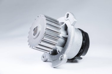 Bir degrade ile gri bir arka plan üzerinde bir motor su pompası soğutma için yeni metal otomobil pompası. Otomobil motoru için yeni yedek parça konsepti