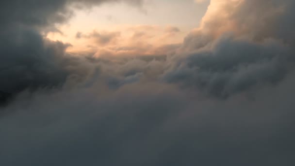 Aerial view flying through cumulus thunderclouds at sunset. Gold colored sunset cloudiness in high contrast. Real sky. The concept of dreams and weather forecast — Stock Video