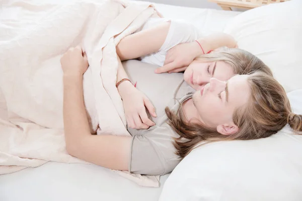 A young long-haired couple man and woman sleep in a hug in bed. The concept of healthy sleep in a young family — Stock Photo, Image