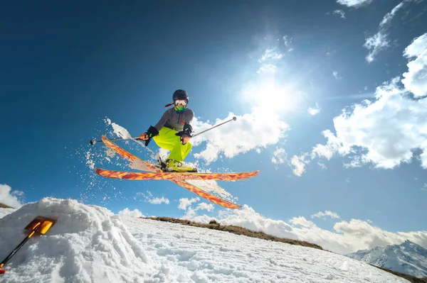 Skirennläuferin im Flug nach einem Sprung von einem Kicker im Frühling gegen Sonne und blauen Himmel. Weitwinkel aus nächster Nähe. — Stockfoto
