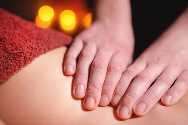 Närbild manliga händer av en professionell massage terapeut gör professionell anti-celluliter massage till en kvinnlig klient i ett mörkt rum — Stockfoto