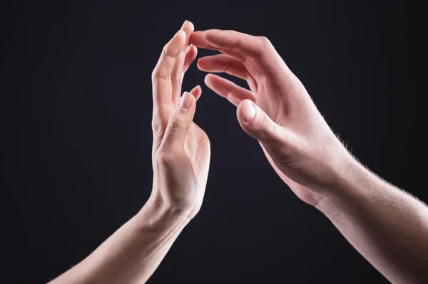 Een close-up van twee handen raken man en vrouw elkaar voorzichtig aan. Het begrip trillende afstoting tussen de geslachten — Stockfoto