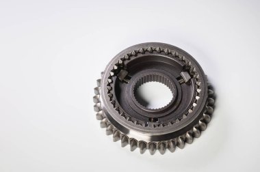 Gri arka planda yeni bir vites parçası. Yeni parçalar ve yedek parçalar kavramı