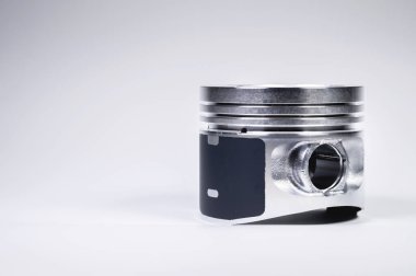 İçten yanmalı motorun yeni pistonu. Gri gradyan arka planında toz var. Yeni motor parçaları kavramı