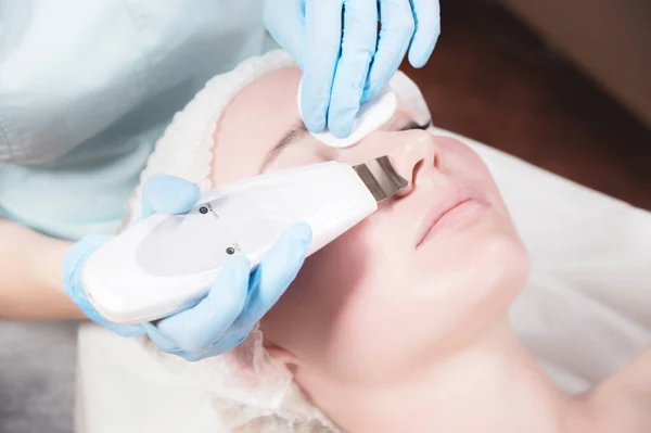 Las chicas cercanas en el salón de belleza limpian la cara con ultrasonido. Concepto de cuidado facial —  Fotos de Stock