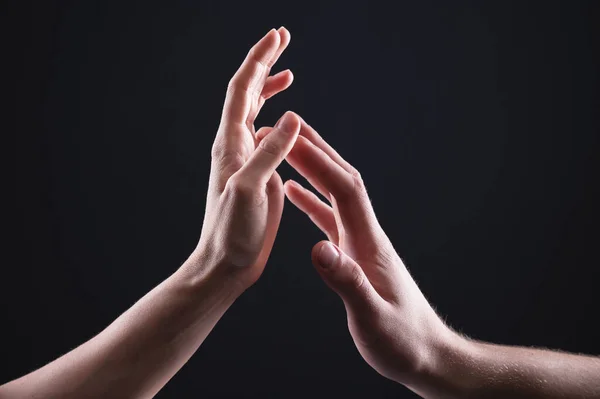 Een close-up van twee handen raken man en vrouw elkaar voorzichtig aan. Het concept trillende afwijzing tussen de geslachten — Stockfoto