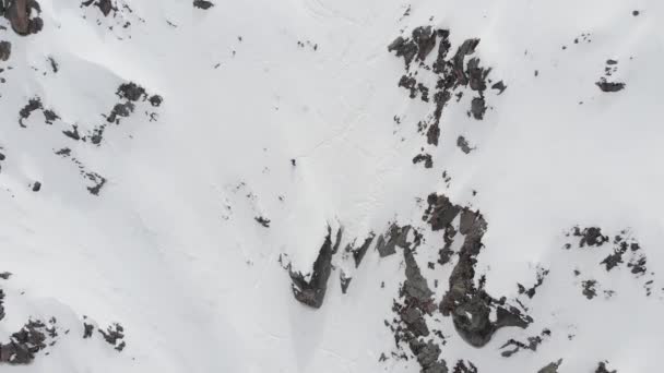 Flygfoto över en backcountry skidåkare rider freeride på en brant sluttning. Professionell skidåkning extrem i bergen i Alperna eller norra Kaukasus — Stockvideo