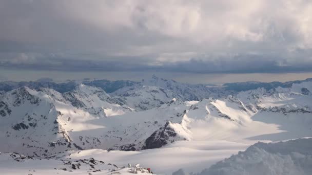 Timelapse da un'altezza di 4000 metri alte rocce innevate con ghiacciai e montagne della dorsale caucasica principale con tramonto serale nuvole arancioni e ghiacciai sulle cime delle montagne . — Video Stock