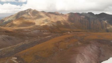Dağlardaki volkanik kayaların üzerinden Elbrus Dağı 'nın arka planına ve büyük bir buzulun üzerine alçak uçuşlar. Dağ Seyahati ve Tırmanma Kavramı Uhd 4k