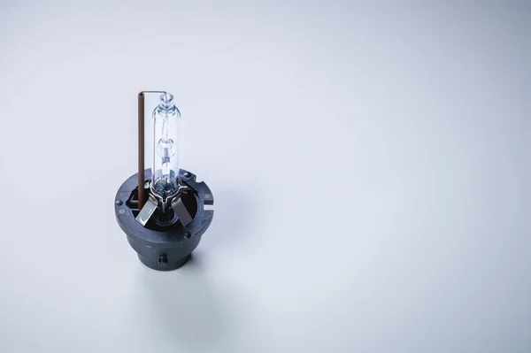Nueva lámpara de xenón sobre un fondo gris degradado. El concepto de lámparas de descarga para reemplazar las lámparas incandescentes convencionales — Foto de Stock