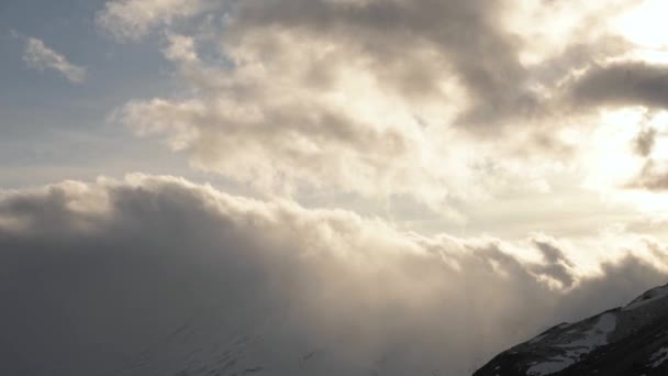 Ηλιοβασίλεμα timelapse ψηλά στα βουνά συννεφιά μπροστά από σύννεφο κυκλώνα ρέει μέσα από τη βραχώδη κορυφογραμμή βίντεο πρόγνωση καιρού — Αρχείο Βίντεο