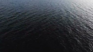 Donanma video geçmişi. Suyun karanlık yüzeyindeki hava görüntüsü küçük dalgalar halinde gider. Alçak tuş