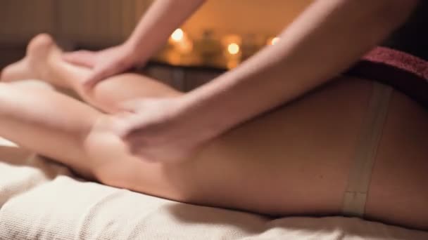 Крупним планом професійний масаж стегна в спа-салоні з приємним теплим світлом. Чоловічий масажист робить преміальний масаж для жіночого клієнта. Боротьба з целюлітом та професійним доглядом за тілом та шкірою — стокове відео