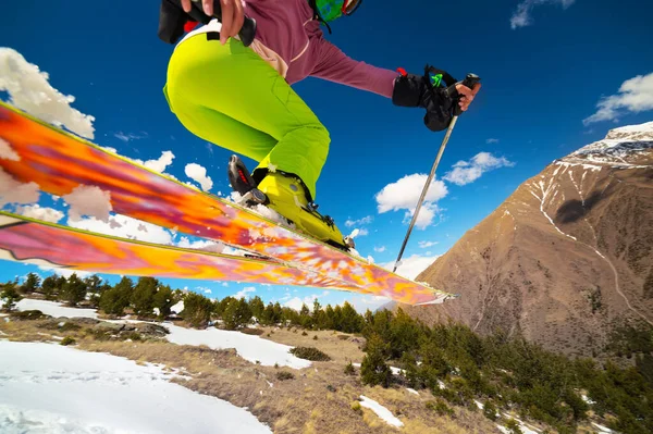 Fille skieuse en vol après avoir sauté d'un kicker au printemps sur fond de montagnes et de ciel bleu. Gros plan grand angle. Le concept de la fermeture de la saison de ski et du ski au printemps — Photo