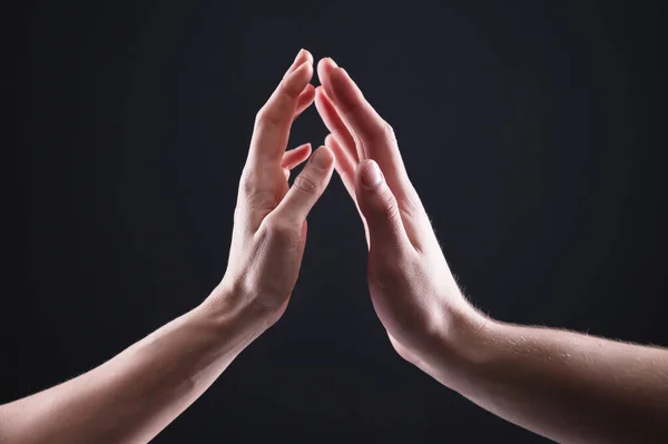 Een close-up van twee handen raken man en vrouw elkaar voorzichtig aan. Het concept trillende afwijzing tussen de geslachten — Stockfoto