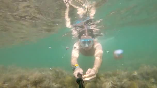 Uma selfie disparada debaixo de água por um homem caucasiano que ostenta um físico flutua lindamente debaixo de água. O conceito de mergulho livre e recreação na costa do mar ou no oceano — Vídeo de Stock