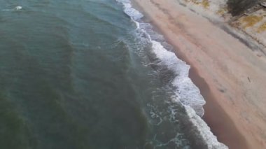 Akşam günbatımından hemen sonra Baltık Denizi kıyı şeridi üzerindeki uçuşun havadan görüntüsü. Kuşbakışı bakış açısıyla denizin arka planına ait bir video kavramı